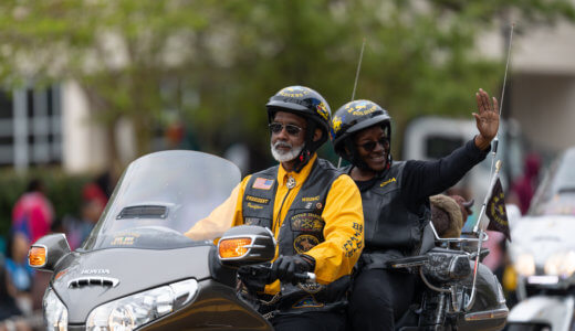 Two veterans on a motorcycle waiving
