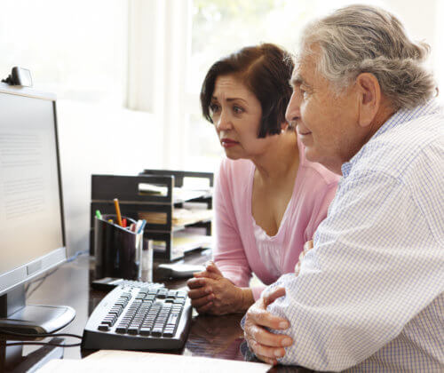 Senior man and woman looking at a computer screen