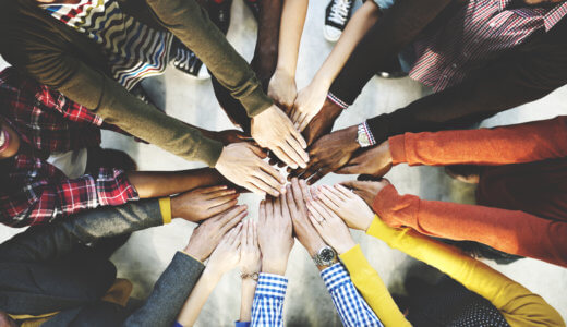 Group of people with their hands outstretched in a circle